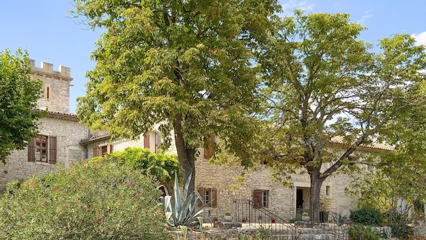 A stone building with a tower, surrounded by lush greenery and a staircase leading to the entrance. - 1 bedroom nice home in Carnas (Carnas)