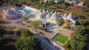 A village with stone houses, a swimming pool, and a soccer field. - Apartment 'Trullo Fico' with Shared Pool, Shared Terrace and Wi-Fi (Martina Franca)