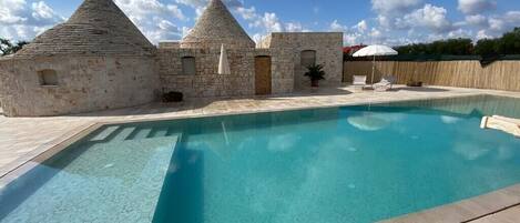 A swimming pool with stone buildings in the background.