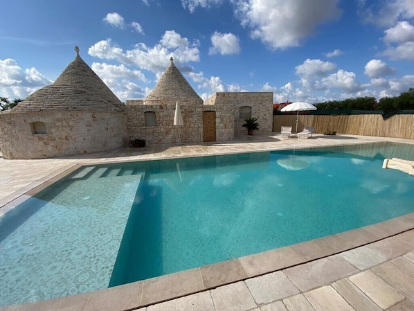 A swimming pool with stone buildings in the background.