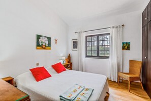 A room with a bed, a chair, a window, and artwork on the walls. - Holiday Home 'Vila Das Manas' with Private Pool, Private Garden and Wi-Fi (Verdizela)