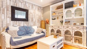 A living room with a white sofa, a white coffee table, and a white cabinet with glass doors. - Apartment 'Cristina Center' with Balcony, Wi-Fi and Air Conditioning (València)