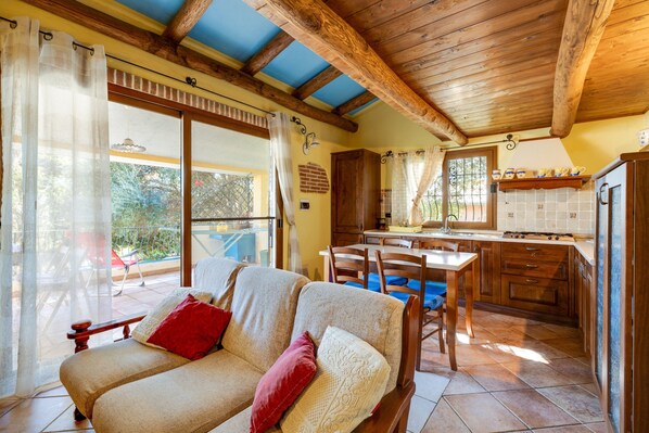 A cozy living area with a sofa, a dining table, and a kitchen in the background.