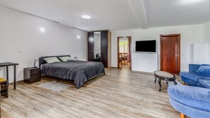A bedroom with a bed, bedside table, and a TV mounted on the wall. - Apartment 'Apartamento T2 Praia Do Almoxarife' with Sea View, Wi-Fi and Air Conditioning (Horta)