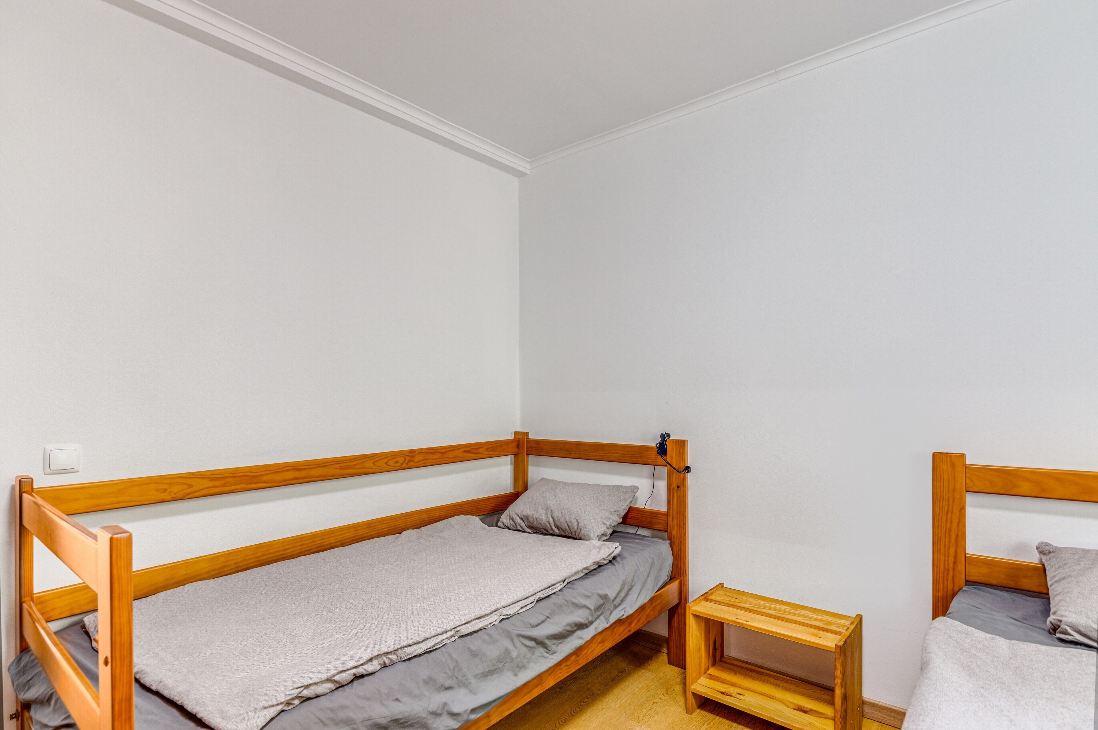 Ein einzelnes hölzernes Etagenbett mit einem kleinen Nachttisch daneben.