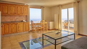 A room with a kitchen, dining area, and a balcony with a view. - 'Finca La Calerita C' with Sea View (Yaiza)