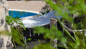 A hammock tied to a wooden post, a pool, and surrounding greenery. - 'Finca La Calerita C' with Sea View (Yaiza)