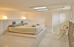 A bedroom with a bed, a chair, a wardrobe, and a skylight. - 'Finca La Calerita C' with Sea View (Yaiza)