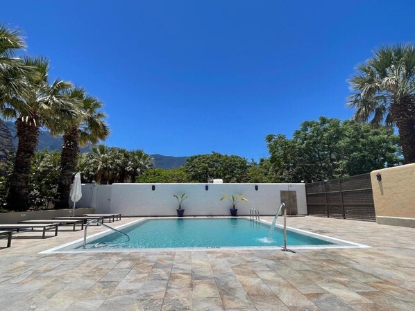 A swimming pool with a clear view of the mountains in the background.