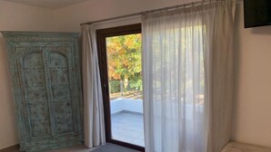 A bedroom with a bed, a wardrobe, a door leading to a balcony, and a small table. - Apartment 'Finca Wapa - Apartamento Mayor' with Sea View, Wi-Fi and Air Conditioning (Frontera)