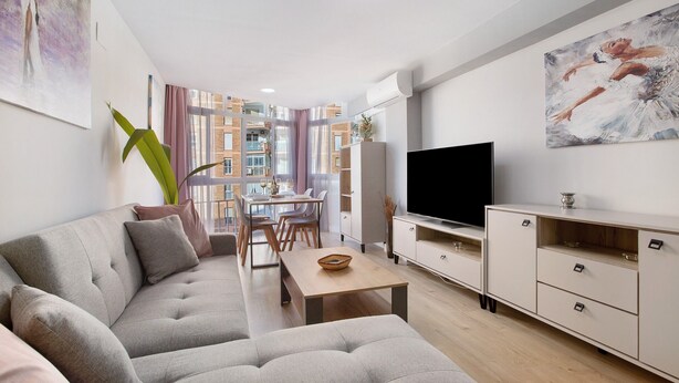 A modern living room with a sofa, TV, and dining area. - Apartment 'Aquario' with Sea View, Wi-Fi and Air Conditioning (Benalmádena)