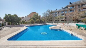 A rectangular swimming pool with a circular design in the center, surrounded by a concrete deck. - Apartment 'Aquario' with Sea View, Wi-Fi and Air Conditioning (Benalmádena)