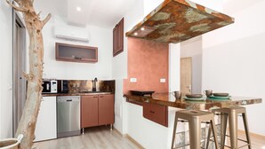 Une cuisine moderne dotée d’un îlot central au style rustique, d’appareils électroménagers en acier inoxydable et d’un design de plafond original.