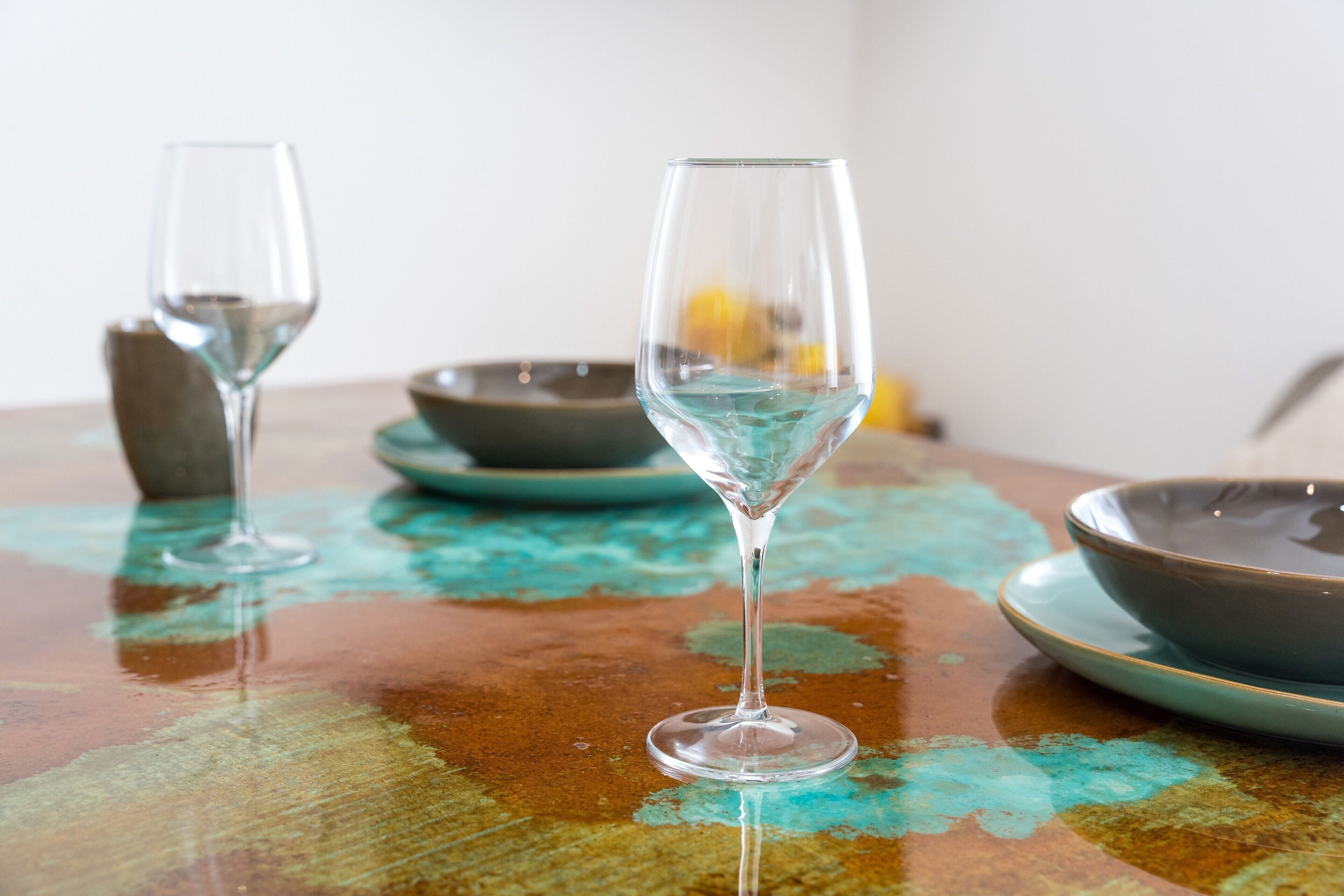 A table with a glass, a bowl, and a plate.