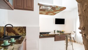 Une cuisine dotée d’un crédence au style rustique, d’un robinet moderne et d’un coin bar avec des tabourets.