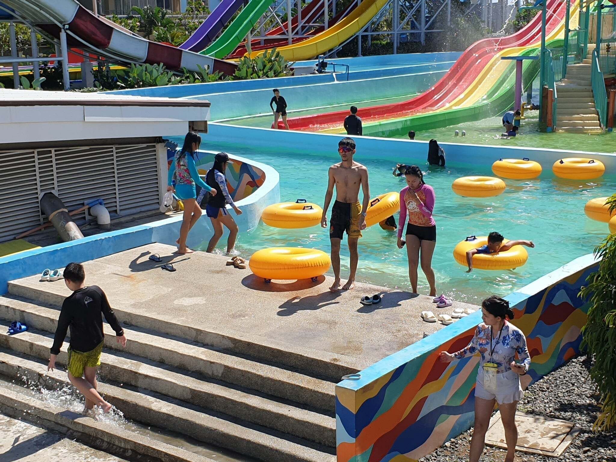 A water park with multiple slides, a pool area, and steps leading down to the water.