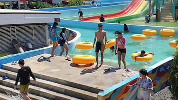 Un parc aquatique doté de nombreux toboggans, d’un espace piscine et d’un escalier menant à l’eau.