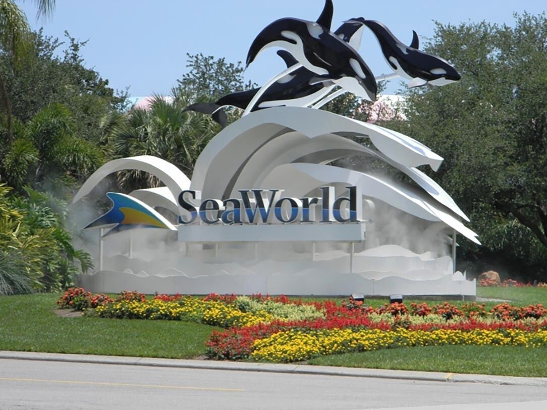 A sign with the text 'SeaWorld' surrounded by a decorative arch and floral arrangements.