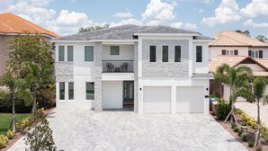A two-story house with a stone facade, a balcony, and a garage. - Beautiful Villa with First Class Amenities in Reunion Resort, Orlando Villa 1011 (Orlando)
