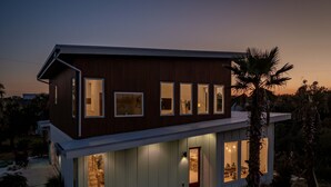 A modern two-story house with a flat roof, large windows, and a covered front porch. - Luxury Retreat w/Games, Patio, BBQ, Close to Beach (Palm Coast)