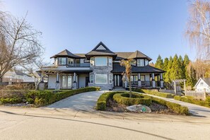 Stunning multi-story building with a central stone base and symmetrical facade, set amidst manicured landscaping.