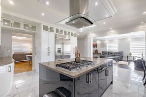 Enjoy cooking in the well-equipped kitchen with a gas stove, ample counter space, and a sleek refrigerator.