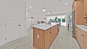 Una cucina moderna con mobili in legno, un'isola grande ed elettrodomestici integrati.
