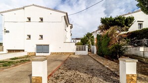 Un edificio blanco con camino de grava y entrada portonada.