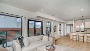 Eine moderne Wohnung mit Wohnzimmer, Küche und Balkon.