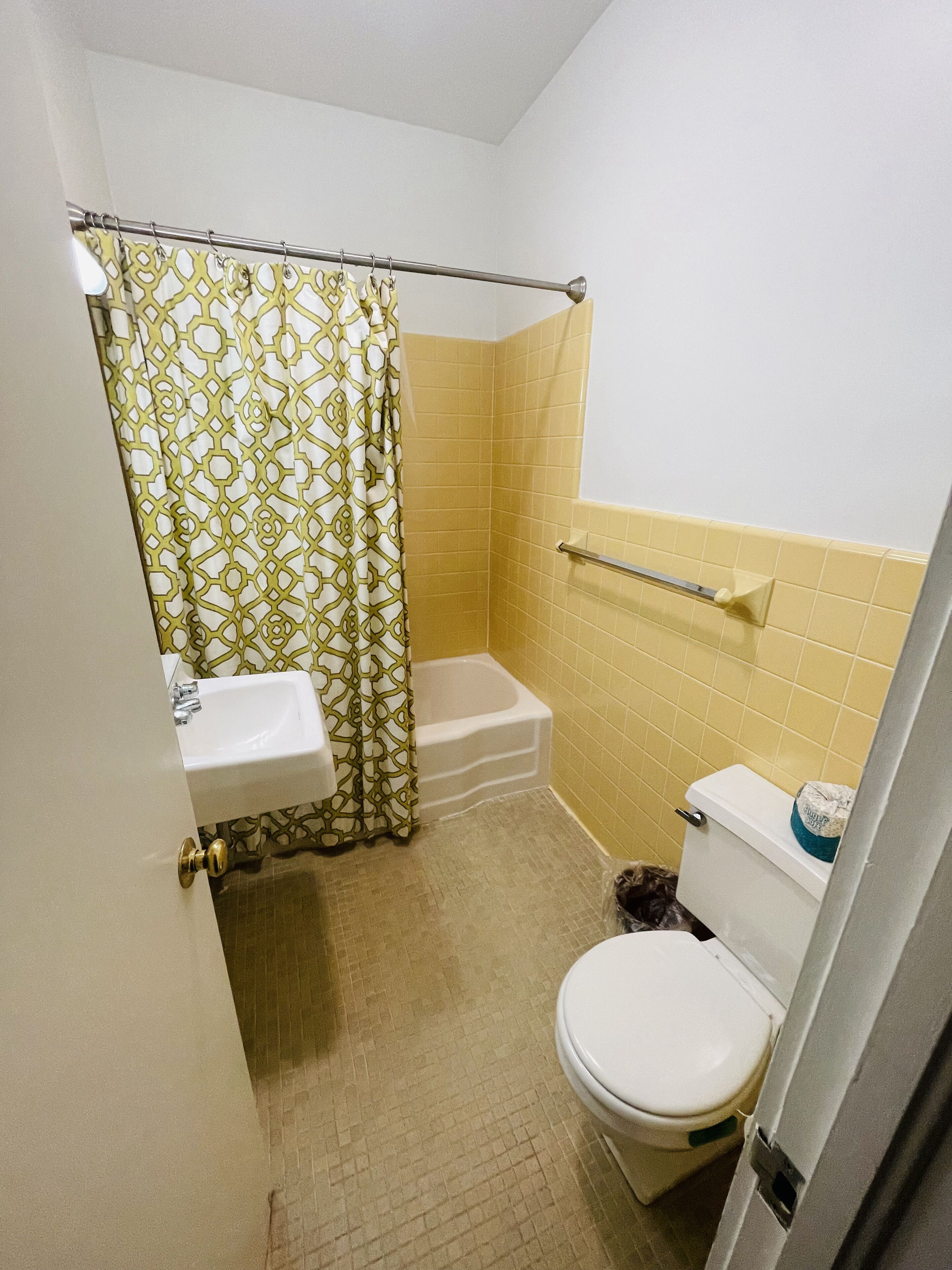 A small bathroom with a toilet, sink, and bathtub.