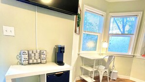 A modern living room with a white desk, a chair, a coffee maker, and storage bins. - XL Sacramento Studio Midtown Downtown NEWLY Renovated - Work Play Stay (Sacramento)