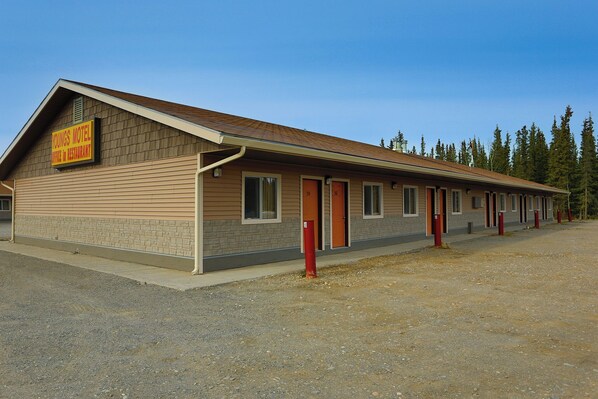 A motel with a single-story structure, numbered rooms, and a visible sign indicating it includes a restaurant.