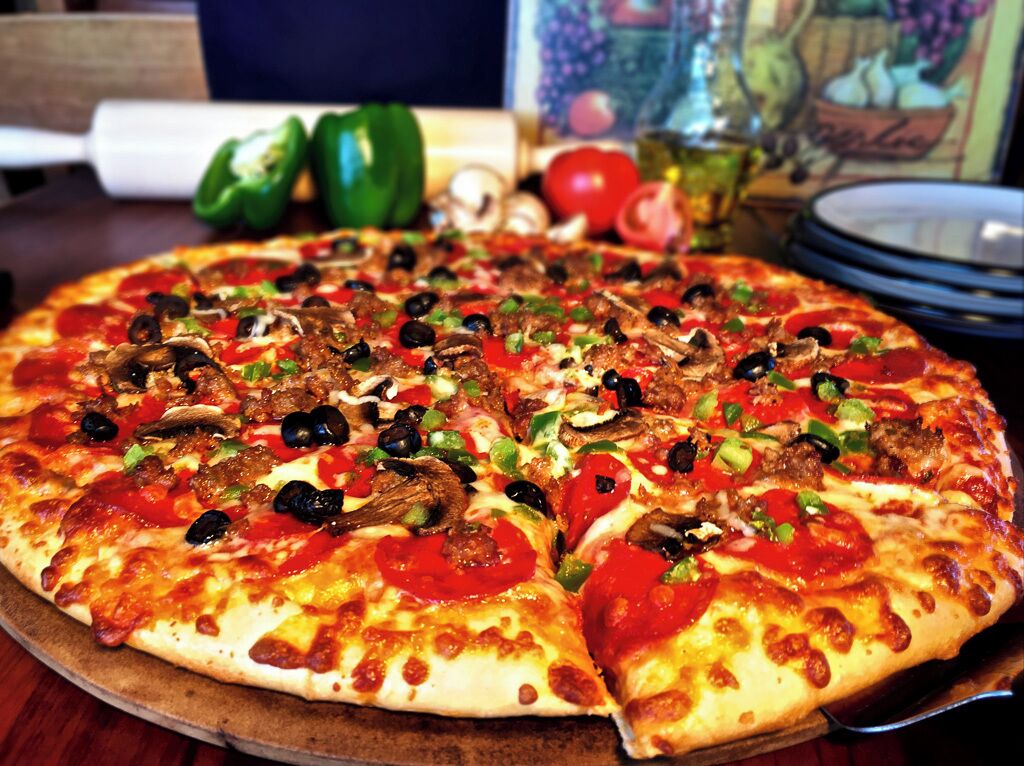 Una pizza con diferentes ingredientes sobre una tabla de madera.