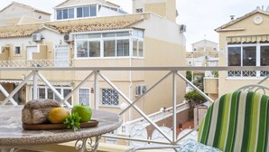 A balcony with a round table, a loaf of bread, a lemon, and an apple. - Bungalow PINK LAGOON (Torrevieja)