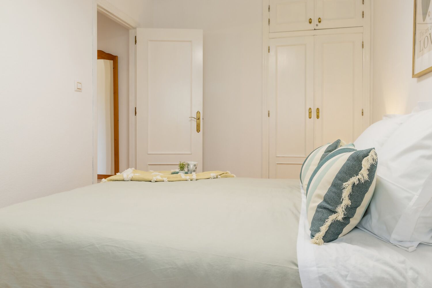 Un dormitorio con cama, mesita de noche y armario.