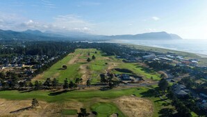 An aerial view of a golf course with houses and a beach in the background. - Gearhart House G638 (Gearhart)