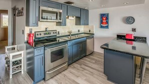 A modern kitchen with stainless steel appliances, a microwave, and a large island. - Gearhart House G638 (Gearhart)