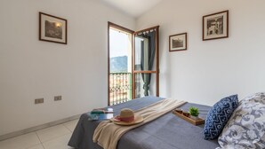Una camera da letto con un letto, una finestra vista e quadri appesi al muro.