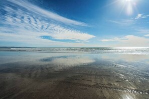 A beach with wet sand and a clear sky. - Poppy Suite I Steps to Dining, Shops + Ferry (Coronado)