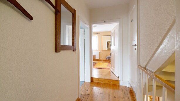 A hallway with wooden flooring, white walls, and a door leading to another room. - Holiday Home 'Haus Gertrud' with Mountain View, Private Terrace and Wi-Fi (Monzelfeld)