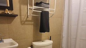 Ein Badezimmer mit Toilette, Waschbecken und einem Handtuchhalter mit Handtüchern.