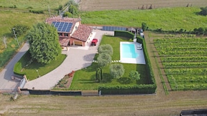 Ein Haus mit Swimmingpool, Solaranlage und Weinbergen.