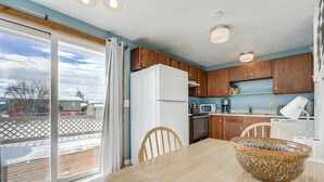 Une cuisine avec des meubles de rangement en bois, un réfrigérateur blanc, un four à micro-ondes et un lave-vaisselle.