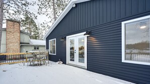 Moderni rakennus, jossa on tumma julkisivu, suuret ikkunat ja tiilestä tehty savupiippu.