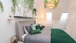 Een moderne slaapkamer met een bed, nachtkastje en een hangende plant.