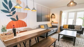 Een moderne woonkamer met een houten eettafel, een bank en een salontafel.