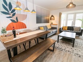 Una sala de estar moderna con una mesa de comedor de madera, un sofá y una mesa de centro.