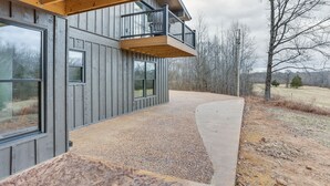 Ein modernes Gebäude mit Balkon, großen Fenstern und einem Schotterweg.