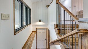 Eine Treppe mit Holzwändern und einer weißen Tür am Fuß.