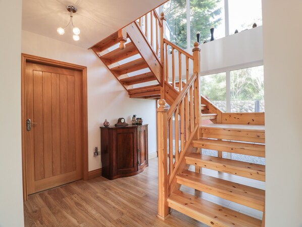 A wooden staircase with a wooden door and a cabinet in a room with wooden flooring.